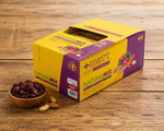 Energieriegel Natural Mix +Watt (Box 24 x 30 g), Box auf einem Holztisch mit getrockneten Cranberries und Nüssen